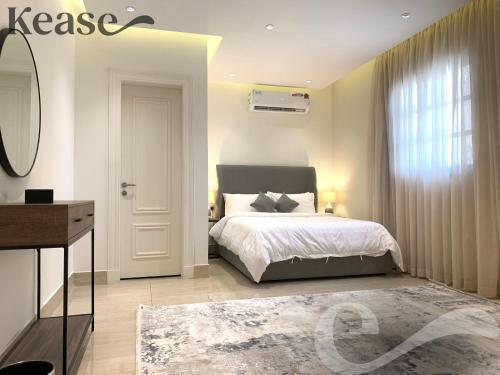 Schlafzimmer mit einem Bett, einem Schreibtisch und einem Fenster in der Unterkunft Kease Ghadeer A-4 Royal touch Terrace XZ99 in Riad