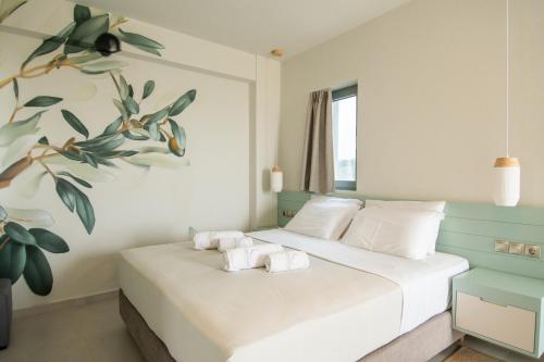 a bedroom with a bed with towels on it at Callisto Seaside Homes & Suites in Marathopolis