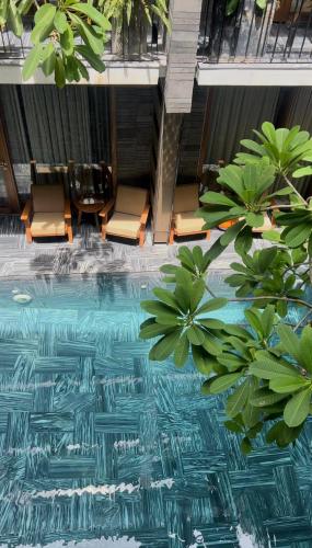 an image of a pool with chairs and plants at Mai's Boutique in Da Nang