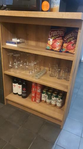 a wooden shelf with jars of food and drinks at Apartmán Bílá Voda in Červená Voda