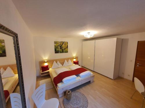 a bedroom with a bed and a mirror and chairs at WASCHERHOF - Ferienwohnungen Oberhofer in Martello