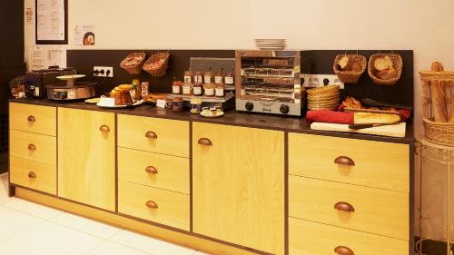 a kitchen with a counter with bread and food on it at Hotel Spa Les Saules in Favières