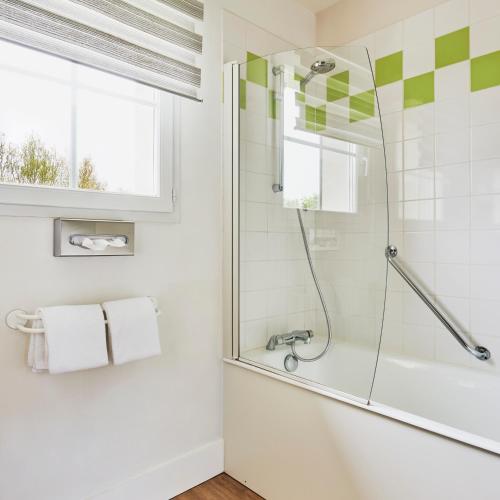 a bathroom with a shower and a sink at Hotel Spa Les Saules in Favières