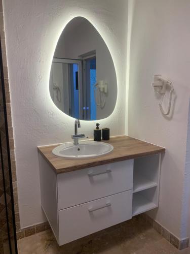 a bathroom with a sink and a mirror at Casa Lucas si Rafael in 2 Mai