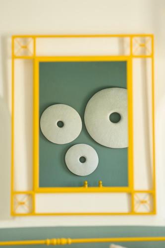 three white discs in a yellow frame at Bellissimo Resort in Agios Ioannis Mykonos