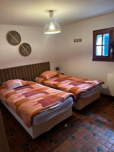 twee bedden naast elkaar in een slaapkamer bij Capeden maison typique in Saint-Hilaire-de-Riez