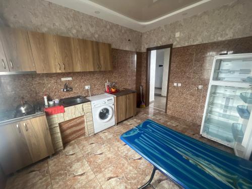 Una cocina con una lavadora y una alfombra azul dentro. en Brilliant712, en Kobuleti