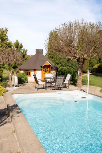 a swimming pool with chairs and a house at Ferienhaus Toni in Ahorntal