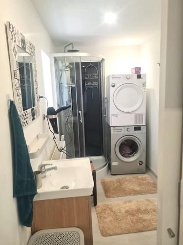 a bathroom with a sink and a washing machine at appartement atypique en triplex in Luze