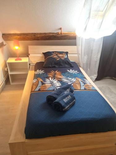 a bed with a blue comforter in a bedroom at appartement atypique en triplex in Luze