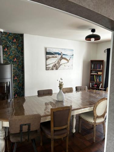 une salle à manger avec une grande table et des chaises en bois dans l'établissement Capeden maison typique, à Saint-Hilaire-de-Riez