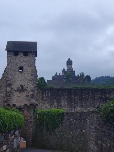 a stone wall with a castle in the background at Ferienhaus Am Balduinstor in Cochem
