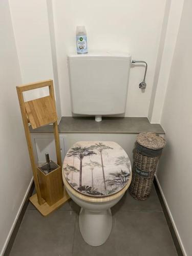 une salle de bain avec des toilettes blanches avec un siège en palmier dans l'établissement Appartement Chez Maria, à Guebwiller