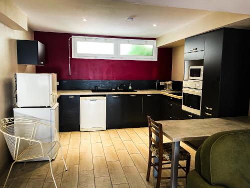 une cuisine avec des appareils en noir et blanc et une table dans l'établissement Appartement 1 chambre, à Peyriac-de-Mer