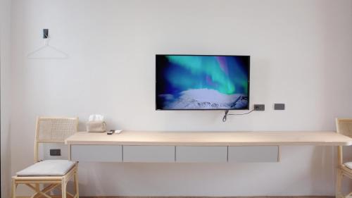 ein Flachbildfernseher, der an einer Wand hängt in der Unterkunft 落跑吧民宿 in Taitung
