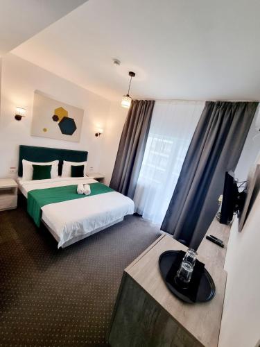 a hotel room with a bed and a television at ZETH HOUSE in Mamaia Sat/Năvodari