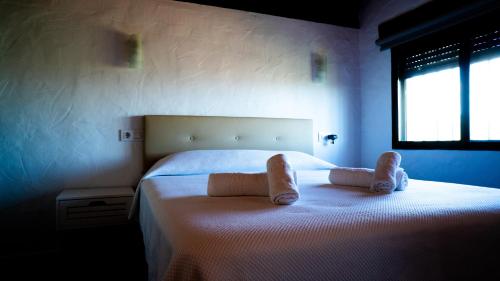 a bedroom with a bed with pair of slippers on it at Rural Tarifa Villa María in Tarifa