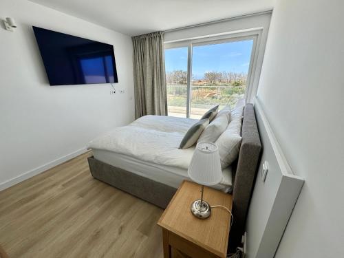 a small bedroom with a bed and a window at Feelgood Homestay Sagres in Sagres