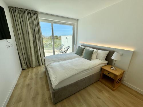 een slaapkamer met een bed en een groot raam bij Feelgood Homestay Sagres in Sagres