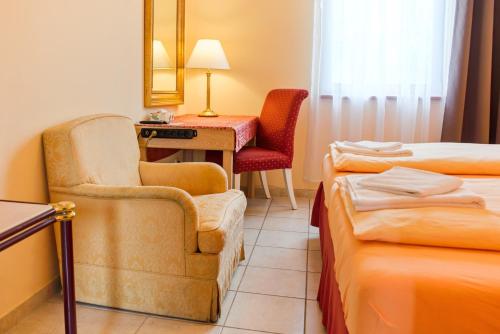 a hotel room with a chair and a desk at Penzion Putim in Putím