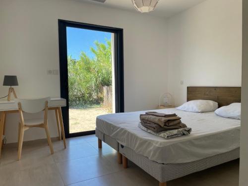une chambre avec un lit, un bureau et une fenêtre dans l'établissement Villa architecte ecume 400m plage, au Cap d'Agde