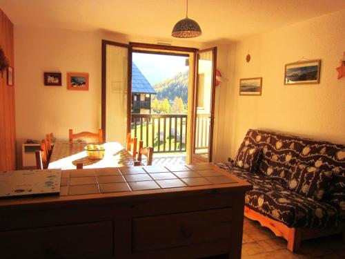 a living room with a couch and a view of a balcony at les Beraudes 1 in Névache