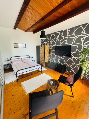 a room with a bed and chairs and a wall at Villa Cvetić in Selce