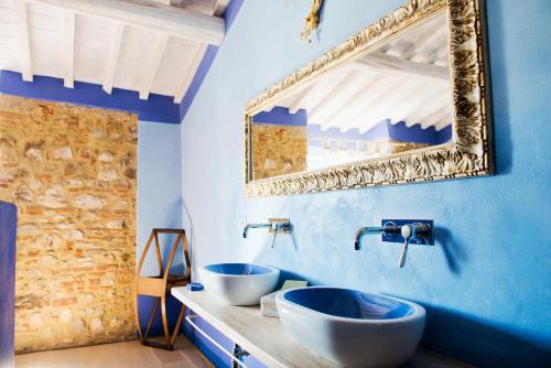 a blue bathroom with two sinks and a mirror at Tenuta Le Tre Virtù in Scarperia