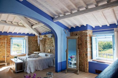斯卡爾佩里亞的住宿－Tenuta Le Tre Virtù，一间拥有蓝色墙壁的卧室和一张带镜子的床
