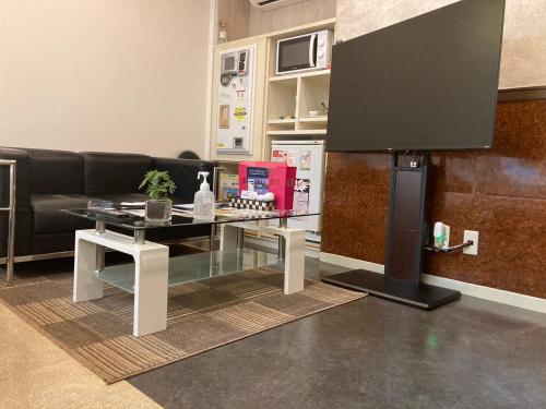 a living room with a glass table and a tv at Hotel Valentine (Adult Only)/Vacation STAY　A館 in Tottori