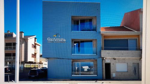 a blue brick building with a sign on it at Cachinnans Hostel & Apartments in Vila do Conde