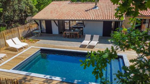 une piscine avec une terrasse et une maison dans l'établissement EVASION BASSIN La Villa Régate Chambres d'hôtes, à Lège-Cap-Ferret