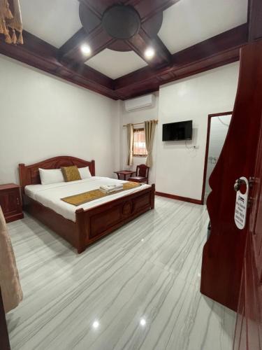 ルアンパバーンにあるPhaiLin Hotelのベッドルーム(ベッド1台、ソファ、テレビ付)