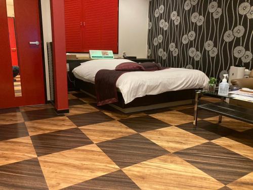 a bedroom with a bed and a checkered floor at Hotel Valentine (Adult Only)/Vacation STAY　A館 in Tottori
