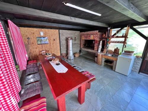 een eetkamer met een rode tafel en een open haard bij Apartments Fuma in Otočac
