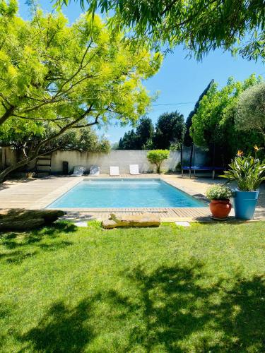 - une piscine dans une cour avec de l'herbe verte dans l'établissement Grande maison, 5 chambres, piscine à 5 min d'Arles, à Fourques