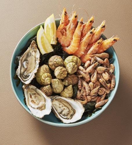 a bowl of oysters and shrimp with lemon slices at Hotel Spa Les Saules in Favières