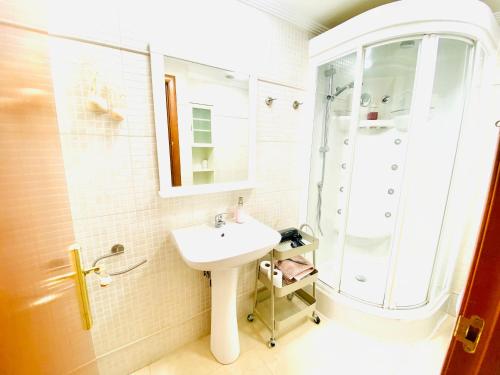 uma casa de banho branca com um lavatório e um chuveiro em Villa Puerto Beach vistas al mar em Altea