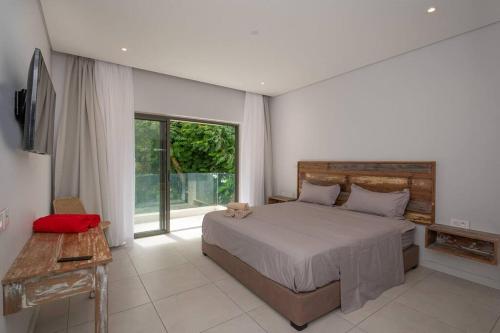 Un dormitorio con una cama y una ventana grande en Luxueux Appartement 3 Chambres situé à La Pointe, en Grand Baie