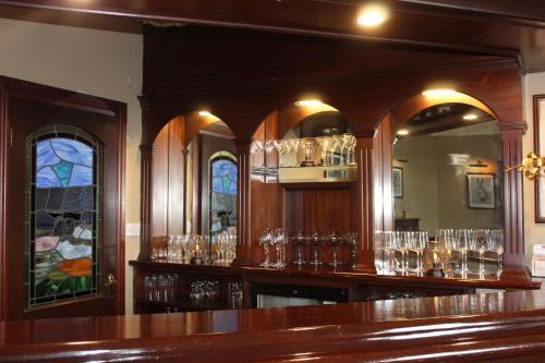 a bar with lots of glasses on the wall at Aran View Country House in Doolin