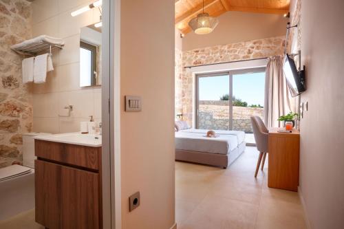 a bathroom with a bedroom with a bed and a sink at Pantheon Luxury Villas in Skala Kefalonias