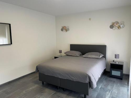 a bedroom with a large bed and two night stands at Vakantiewoning Villa 35 in Maasmechelen