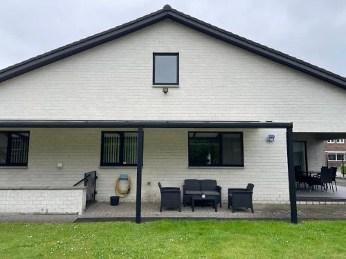 a house with a patio with chairs and a table at Vakantiewoning Villa 35 in Maasmechelen