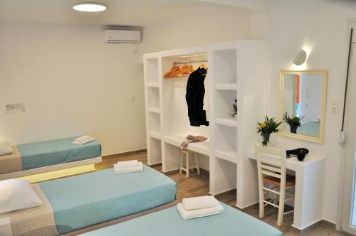 Habitación pequeña con 2 camas y escritorio. en Alexandra Mykonos Port en Mykonos
