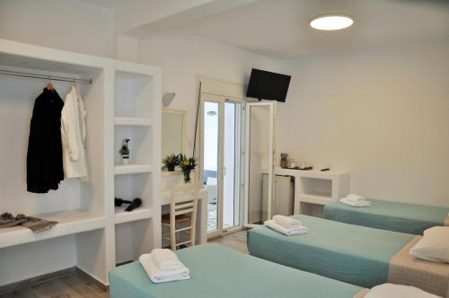 Habitación con 2 camas y espejo. en Alexandra Mykonos Port, en Mykonos ciudad