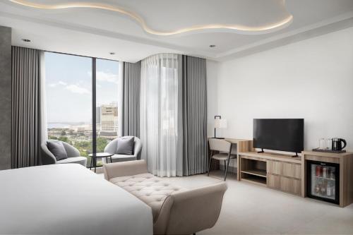 a hotel room with a bed and a television at Chaiya Palace Hotel in Phnom Penh