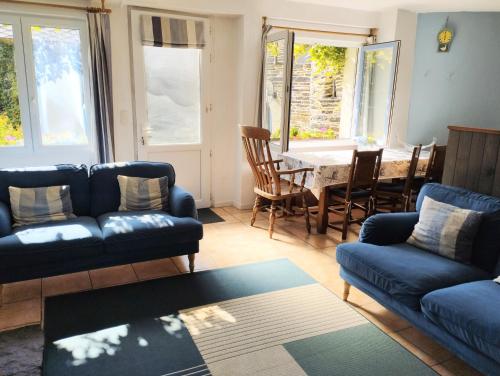 un salon avec deux canapés bleus et une table dans l'établissement The Nightingales, à Laniscat