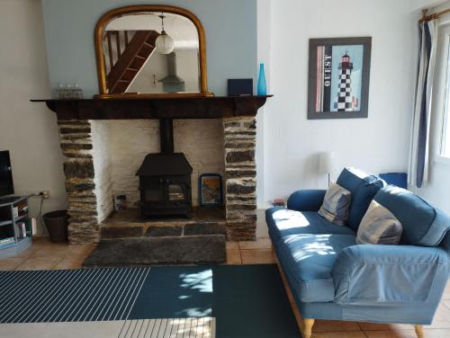 un salon avec un canapé et une cheminée dans l'établissement The Nightingales, à Laniscat