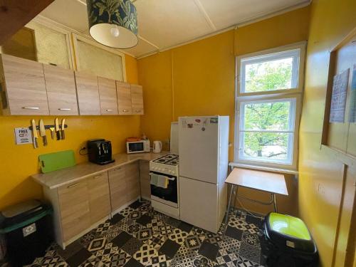 a small kitchen with a white refrigerator and a window at Villa Rekin in Gdańsk