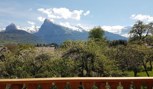 vistas a las montañas con árboles y una valla en Le Gypaète, en Morillon